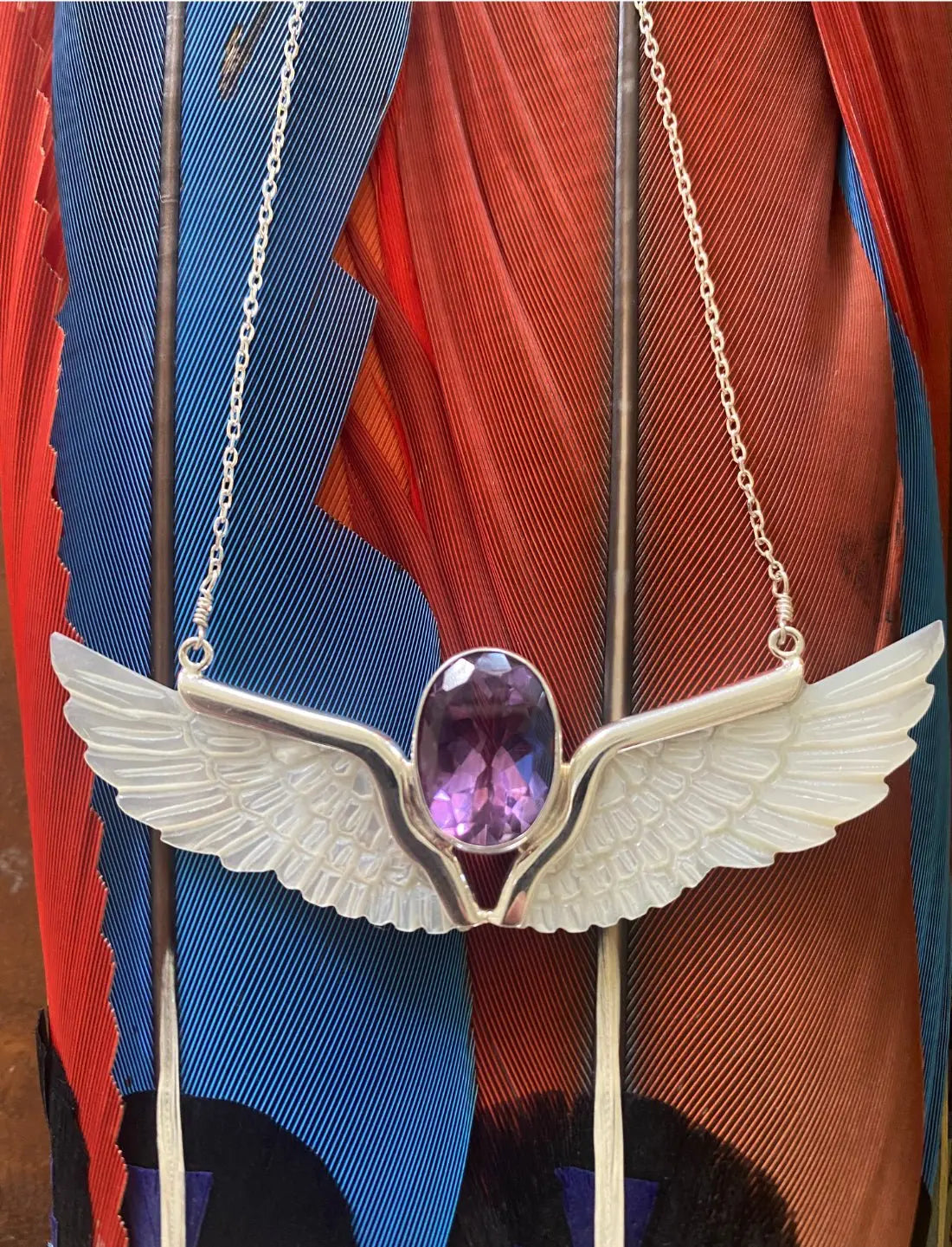 Amethyst Wings Necklace on feathers