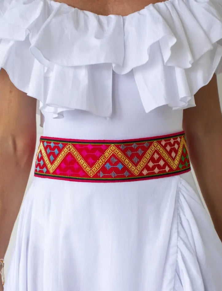 The model wears the Golden Dawn Embroidered Belt across her waistline. The colorful handwoven silk weave displays a beautiful, golden zig zag motif. 