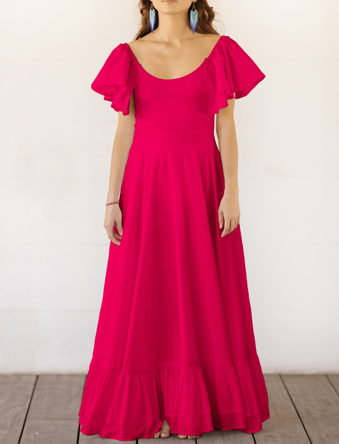 Sacred Hoop of Life Maxi Skirt in vibrant fuchsia with matching flutter sleeve bodysuit and colorful beaded statement earrings. Bohemian wedding dress, ethical fashion, sustainable clothing, beach ceremony gown, simple bridal dress, ruffle hem design, handcrafted apparel, minimalist wedding style, artisan made clothing, summer bridal attire, barefoot elegance photographed against clean white background.