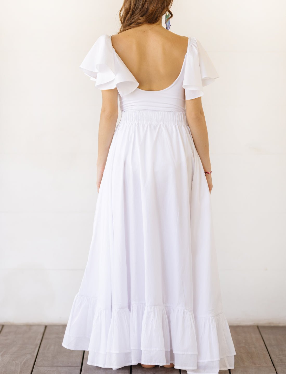 Sacred Hoop of Life Maxi Skirt in pure white shown from back view with matching flutter sleeve top featuring elegant open back design. Bohemian maxi dress, ethical fashion, sustainable clothing, wedding attire, simple bridal dress, ruffle hem detail, handcrafted apparel, minimalist design, artisan made clothing, summer wedding dress, beach ceremony gown photographed against clean white background.